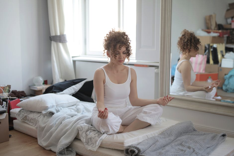 A person in a yoga pose by the window feeling peaceful.